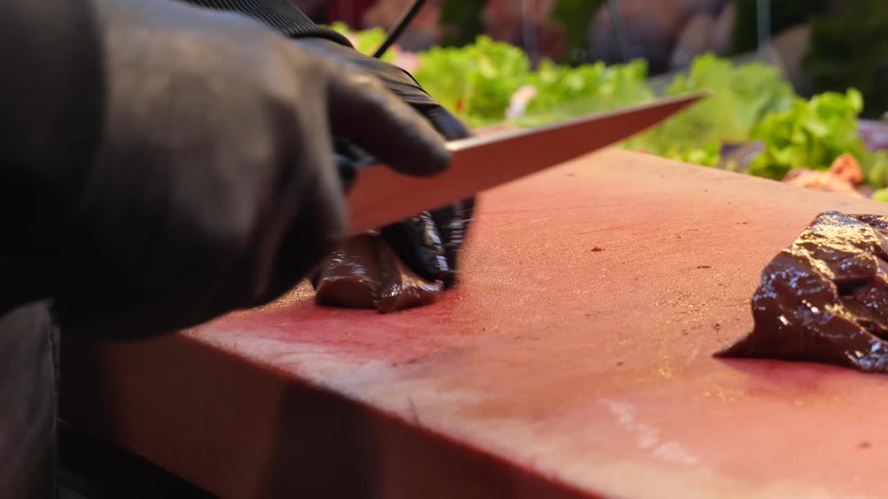 cortando hígado crudo en un mercado