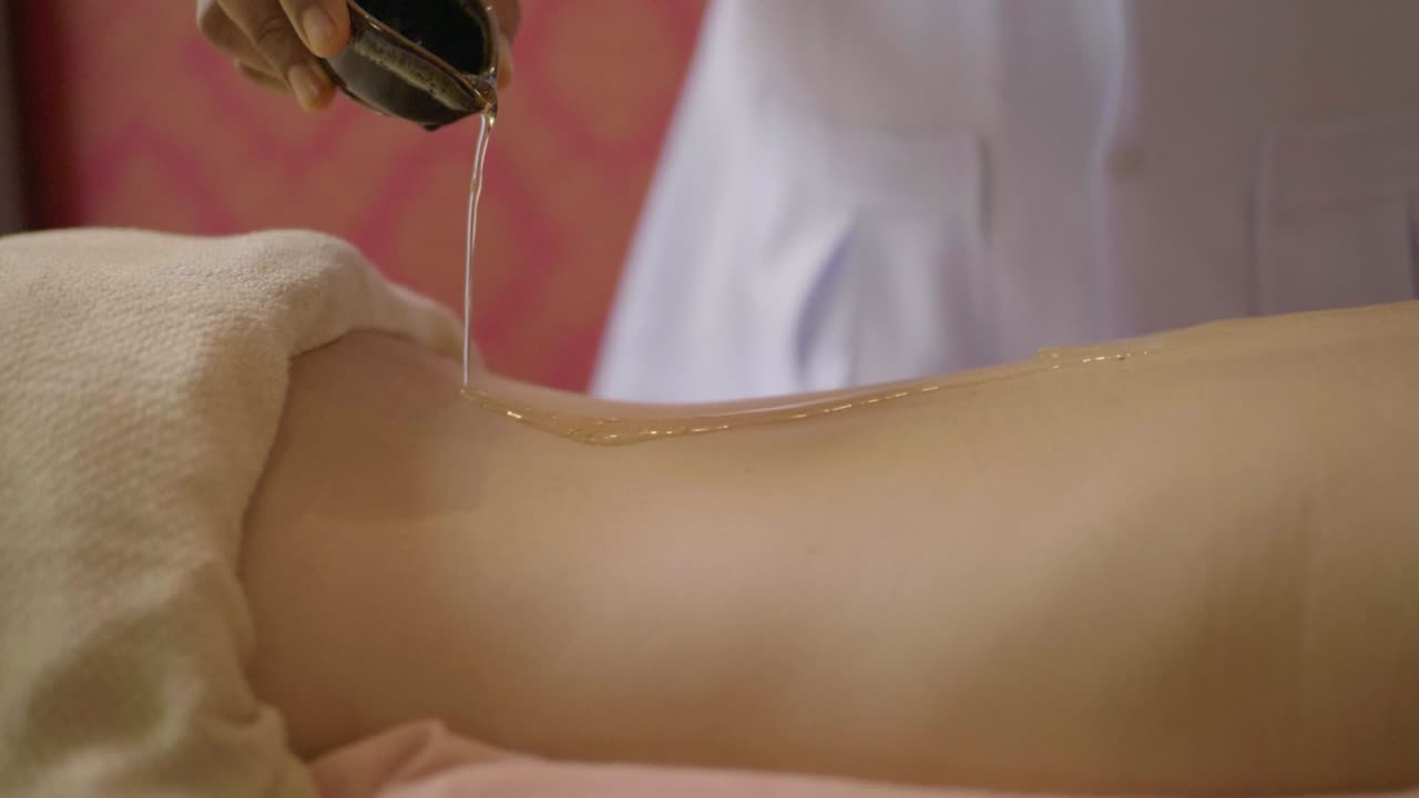 스파에서 등에 마사지 오일을 바르고 있는 여성, 오른쪽에서 왼쪽으로 카메라를 운반하는 여성