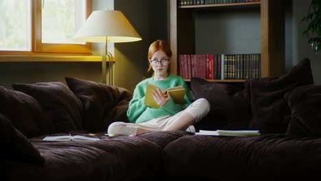 una adolescente leyendo en un sofá