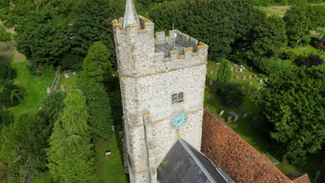 a close-up arc-shot of the church tower of holy cross church in goodnestone