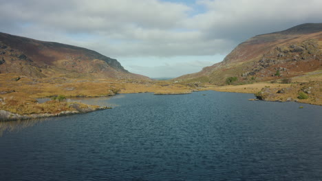 aerial reveal shot, low flying over lake then rise up to reveal the gap of dunloe