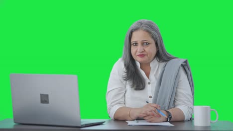 Serious-Indian-senior-businesswoman-talking-to-someone-Green-screen