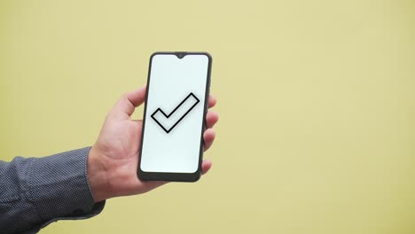 a hand shows approved check mark on a smartphone