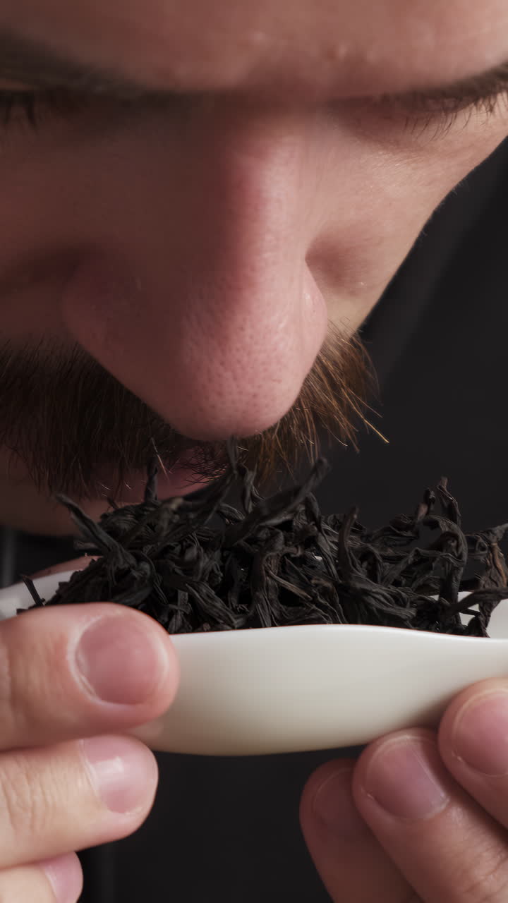 Man Smelling Black Tea Leaves