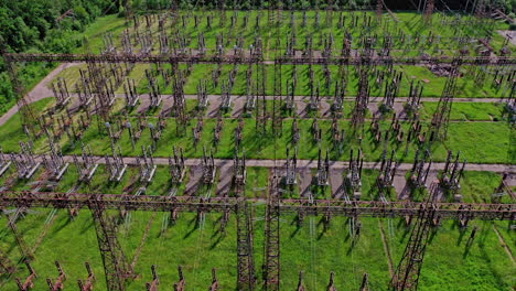 electric supports among green field.flight over huge field with high voltage steel pylons. high voltage lines in nature. aerial view.