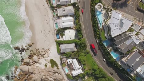 Eine-Vogelperspektive-Zeigt-Autos,-Die-Am-Strand-Von-Camps-Bay-In-Kapstadt-Südafrika-Vorbeifahren-2