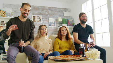 Bearded-man-laughing-hard-while-watching-tv-with-his-friend