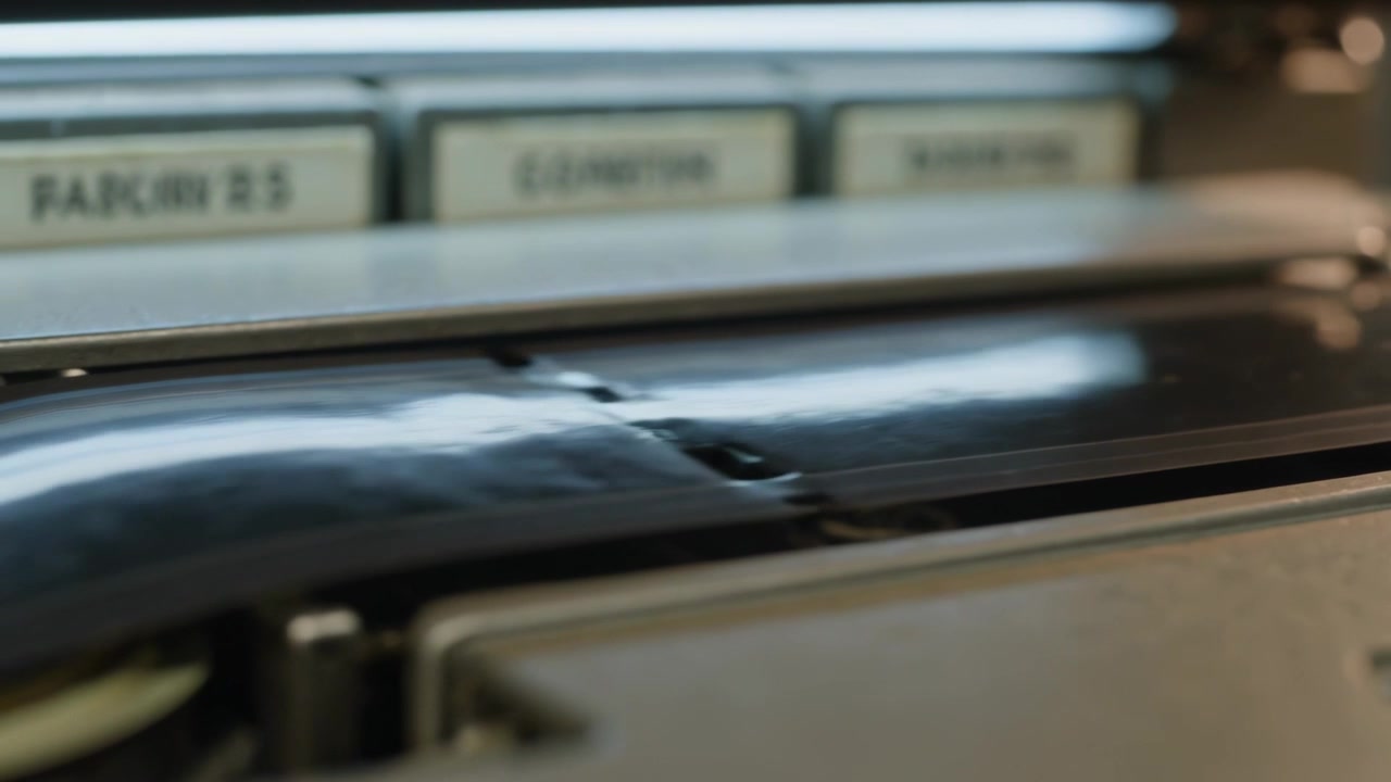 Pulling magnetic tape strip across tape deck, capstan turning while ripple passing under guide