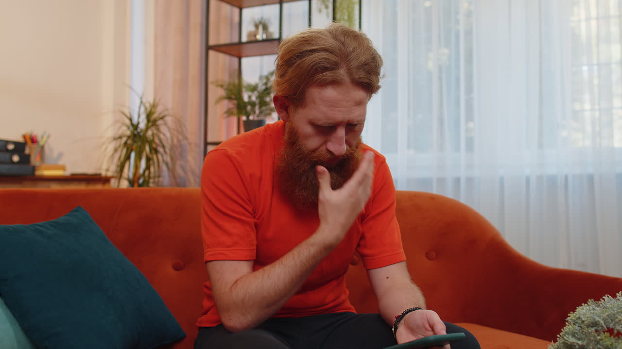 hombre triste barbudo usar smartphone sorprendido por malas noticias, pérdida de fortuna, fracaso, resultados de la lotería, fecha límite