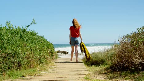 Woman-walking-towards-sea-on-boardwalk-4k