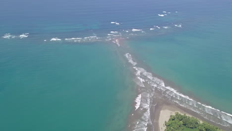 pull back aerial drone shot of whale's tail, uvita beach, costa rica with rising tide