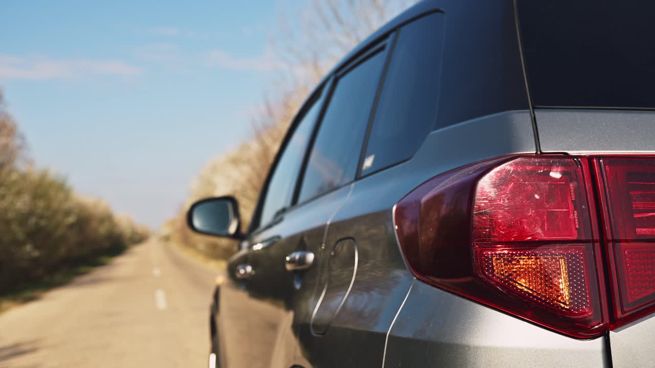 Vista traseira de veículo estacionado em estrada rural com as luzes indicadoras piscando, situação de transporte e na beira da estrada, foco seletivo 4K.