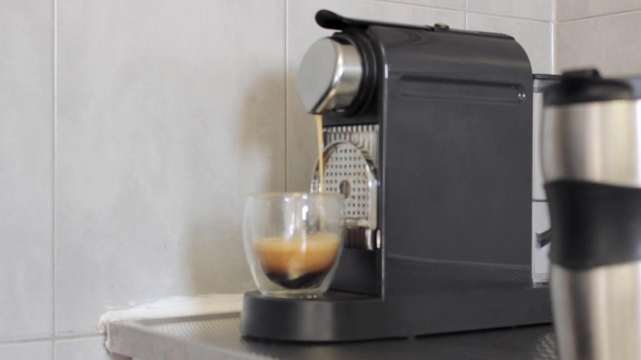 Şeffaf cam bir fincanda otomatik kahve makinesiyle espresso kahve yapımı.