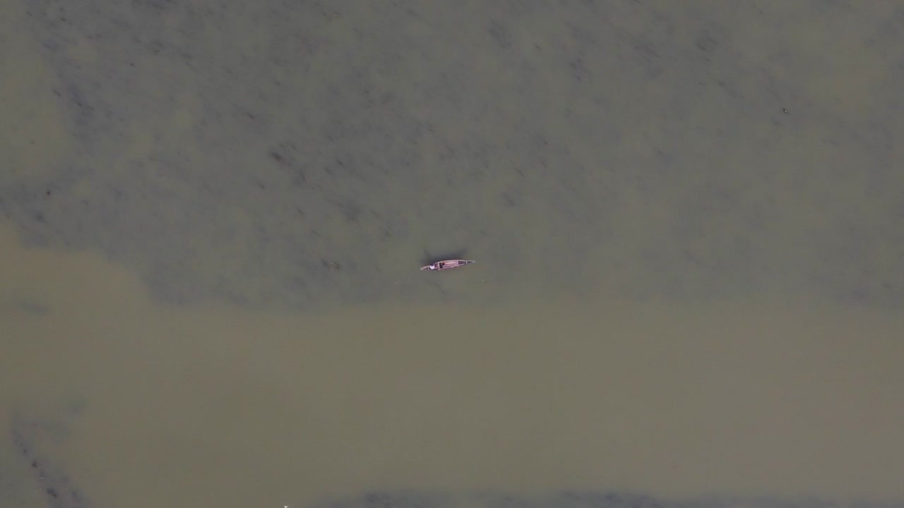 이차마티 강에 떠 있는 전통 목조 보트에 탄 고독한 어부의 공중 하향식 전망