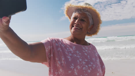 Mujer-Mayor-De-Raza-Mixta-Tomando-Un-Selfie-Con-Un-Teléfono-Inteligente-En-La-Playa