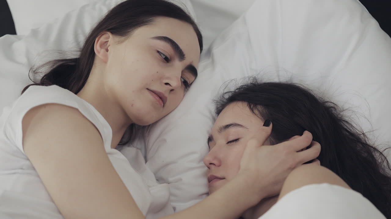 Lesbian couple sleeping in bed