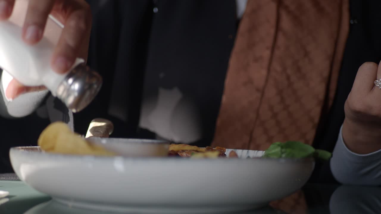 Person Seasoning Food at Restaurant