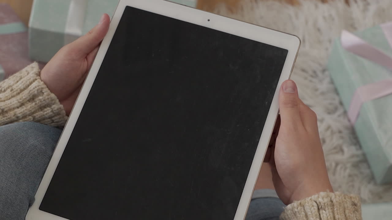 검은 화면 태블릿을 손에 들고