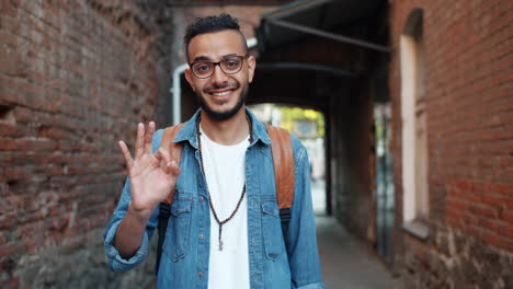 smiling man showing ok gesture in a city alley