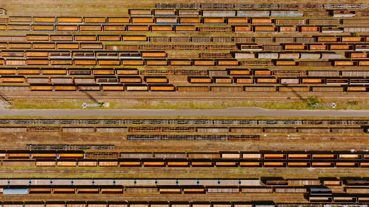Drone slides sideways revealing rows of wagons in industrial harmony