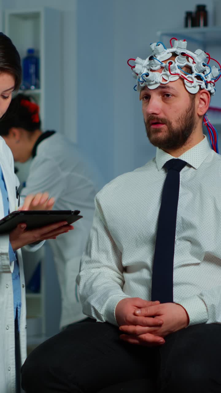 Medical professional adjusts EEG cap on a patient for brain activity monitoring