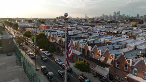 american flag in urban city with skyscrapers on horizon