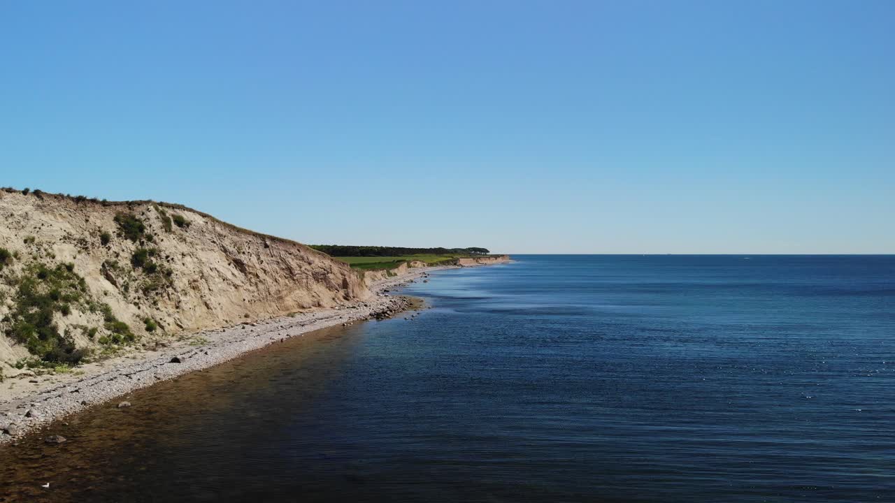 Widok z lotu ptaka na spokojne duńskie wybrzeże z plażą i klifem w upalny letni dzień ze spokojną wodą