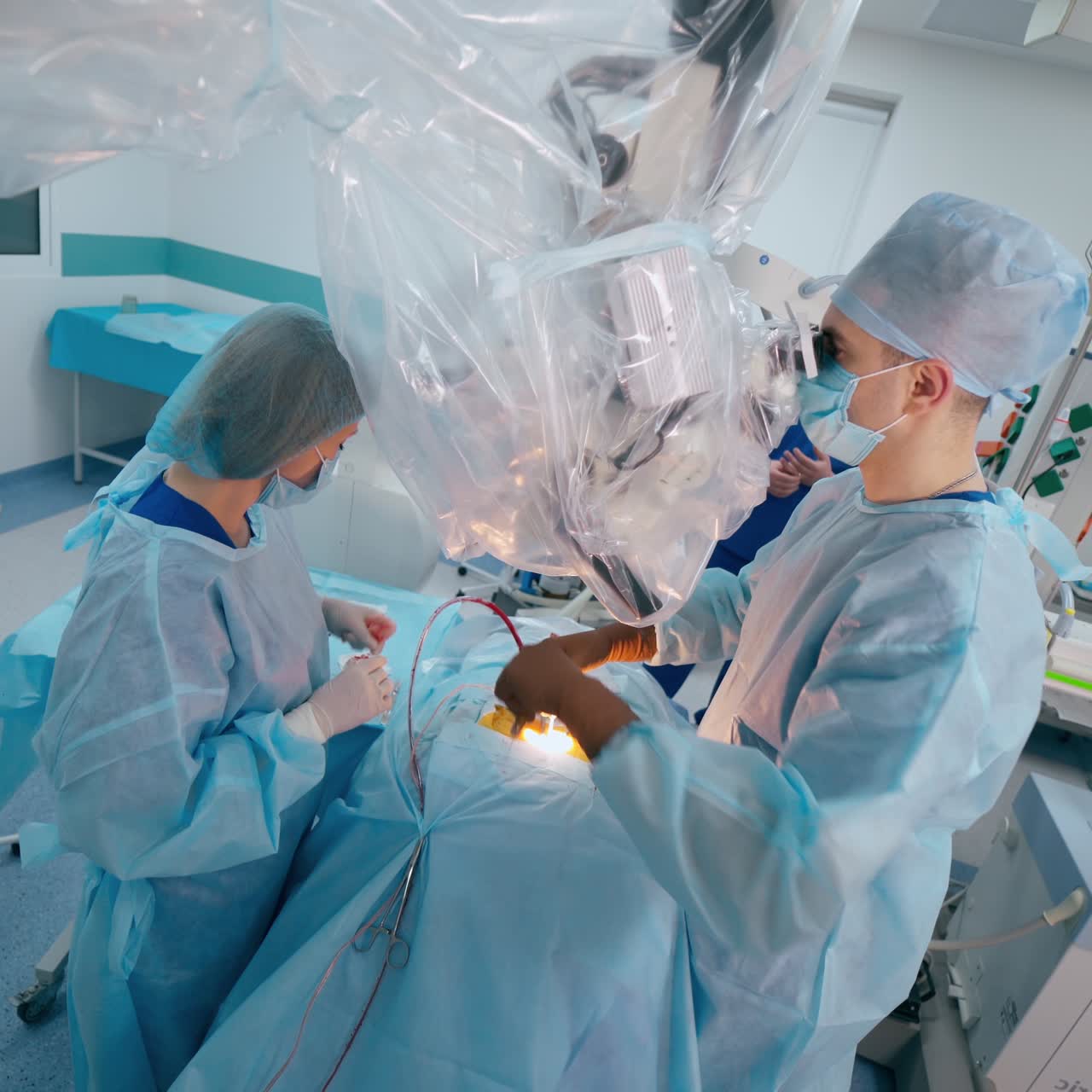 Modern operating room of surgical procedure to patient. Assistant giving instruments to a surgeon during operation. Surgery through the microscope.