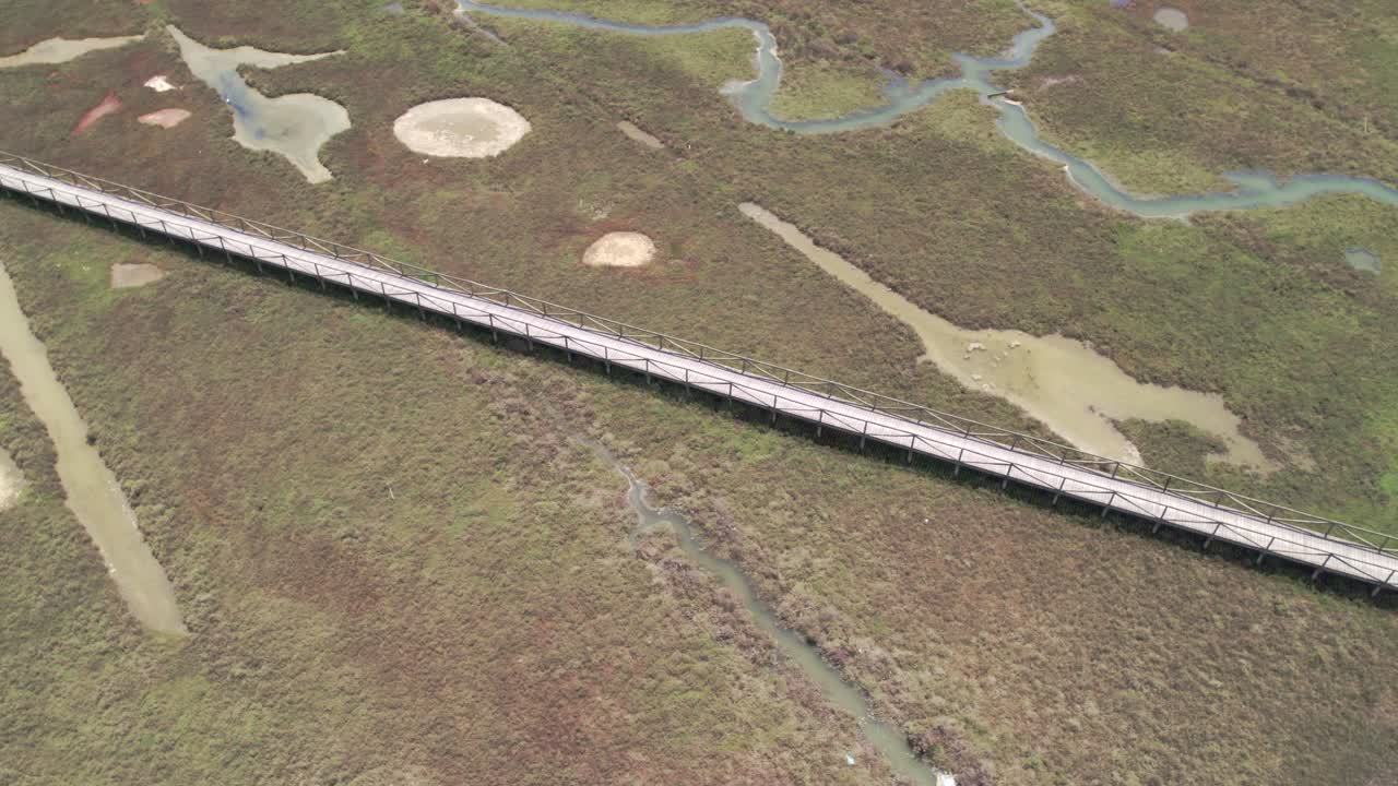 해가 지는 동안 물결이 높을 때 진 ⁇  사이에 있는 나무로 된 산책로