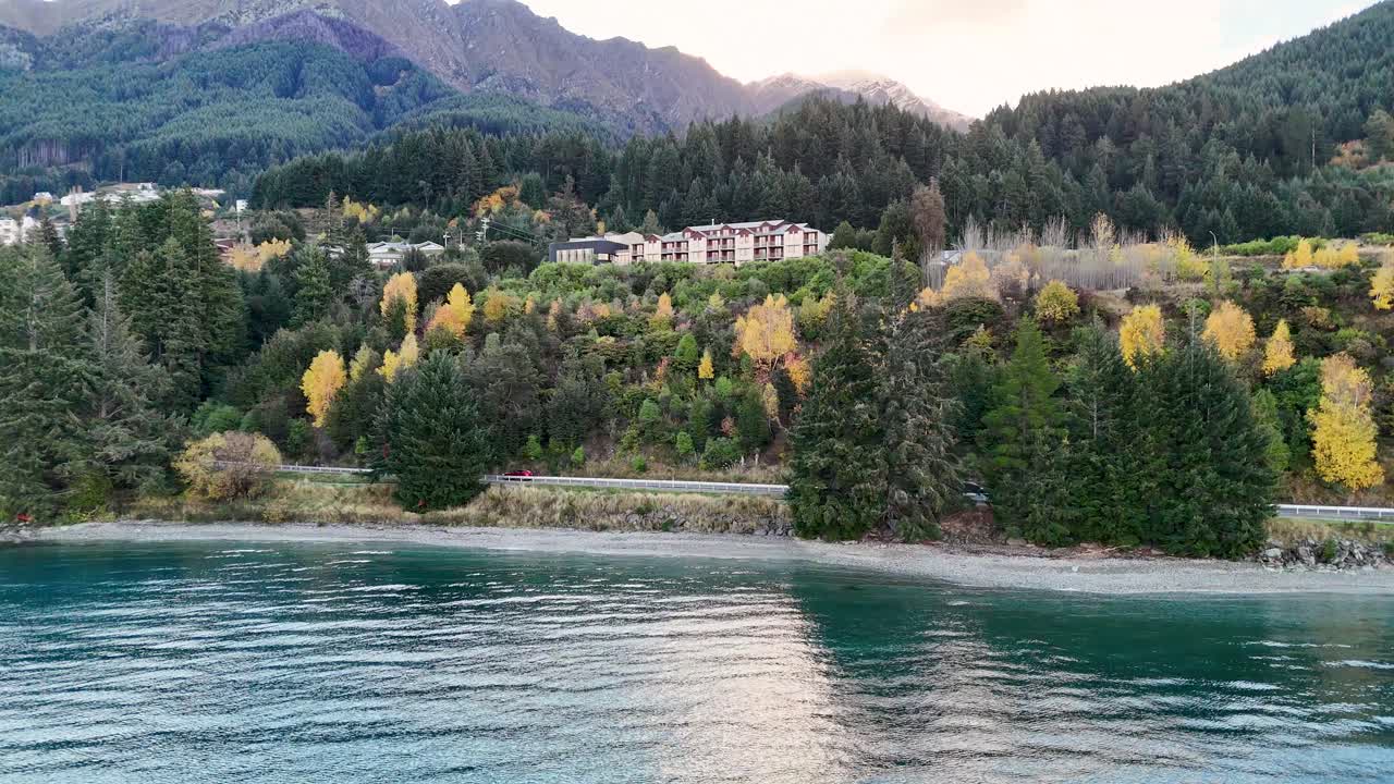 Aerial footage captures the Heritage Hotel surrounded by lush greenery and mountains in Queenstown, New Zealand