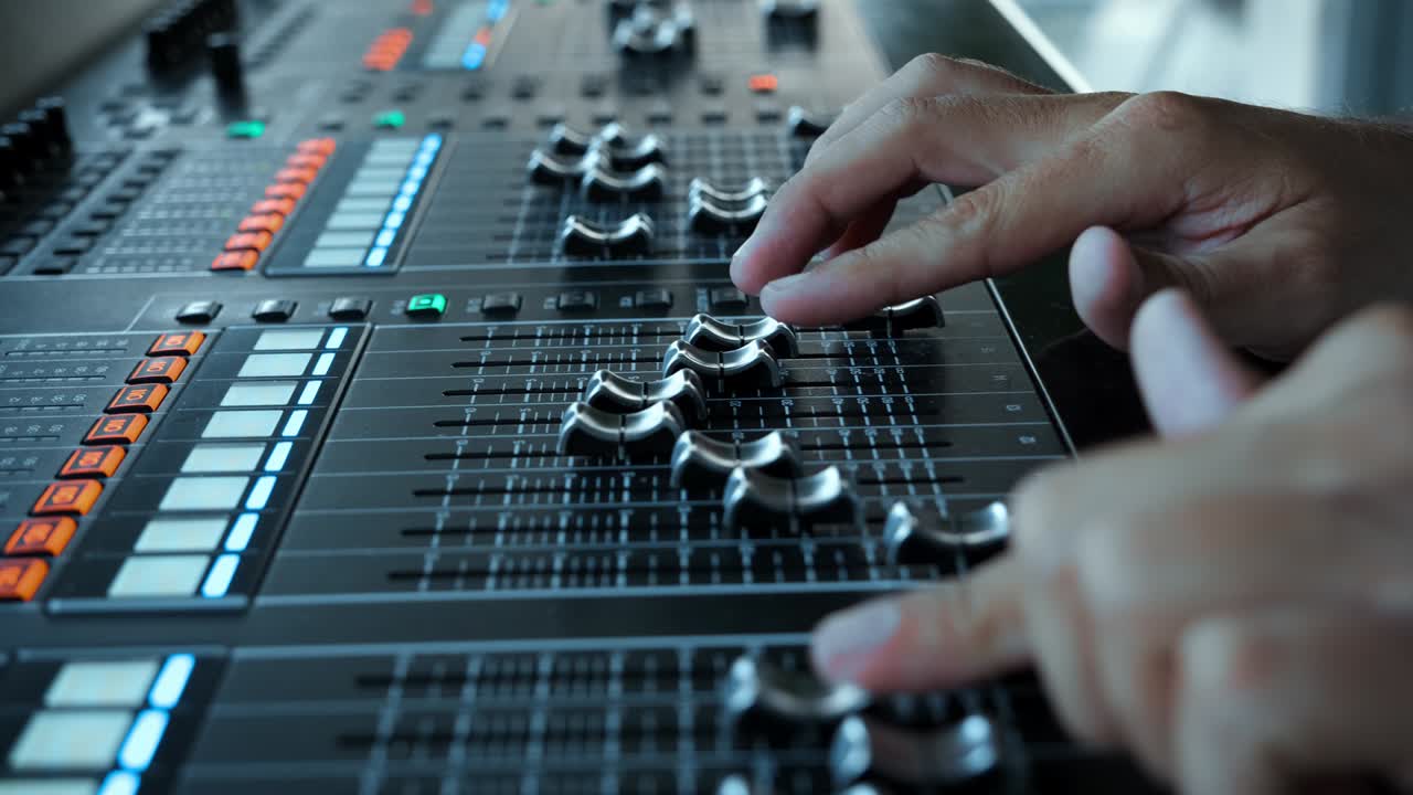 las almohadillas de la placa de sonido en la estación de televisión. el diseñador de sonido usó el mezclador de audio digital en el estudio de producción. el ingeniero de sonido movió los deslizadores en la emisora de radio. el ingeniero presionó los botones de la tecla en el escritorio de control del estudio de grabación.