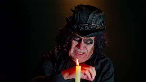 Creepy-mature-man-grandfather-with-Halloween-stylish-witcher-makeup-making-voodoo-magic-rituals