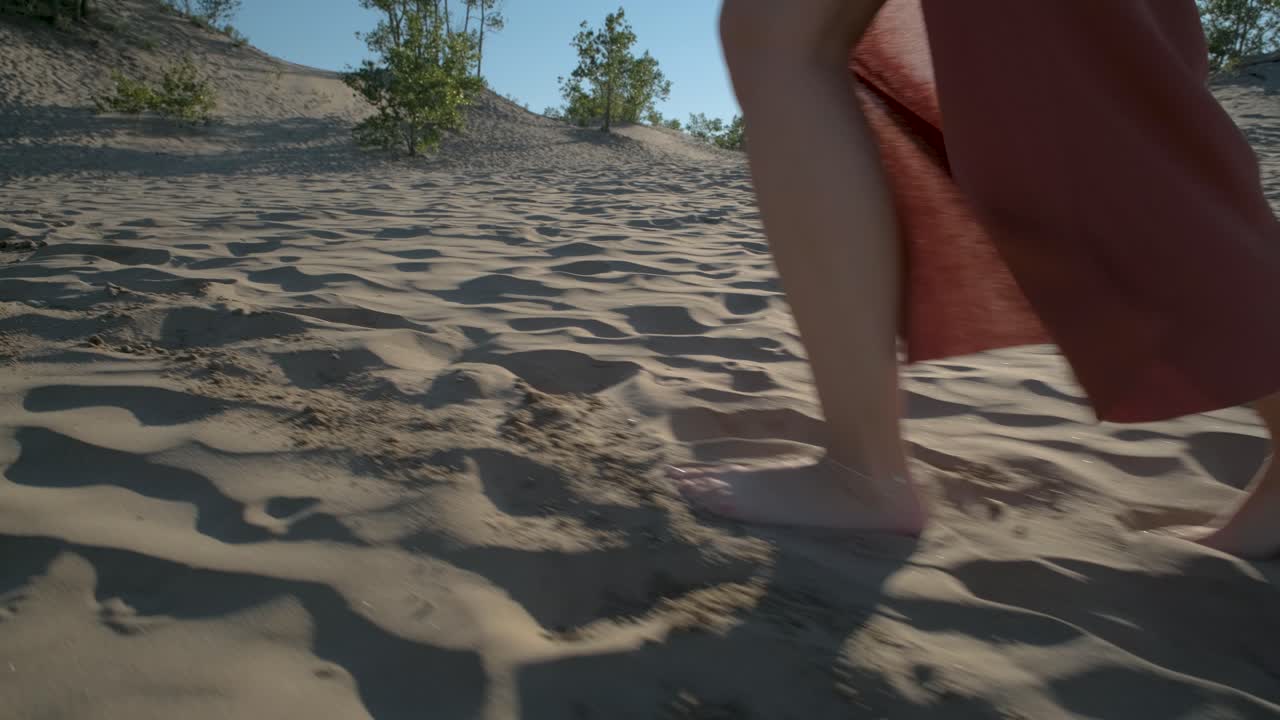 Close up of a woman walking barefoot in the sand dunes of Sandbanks with a beautiful light