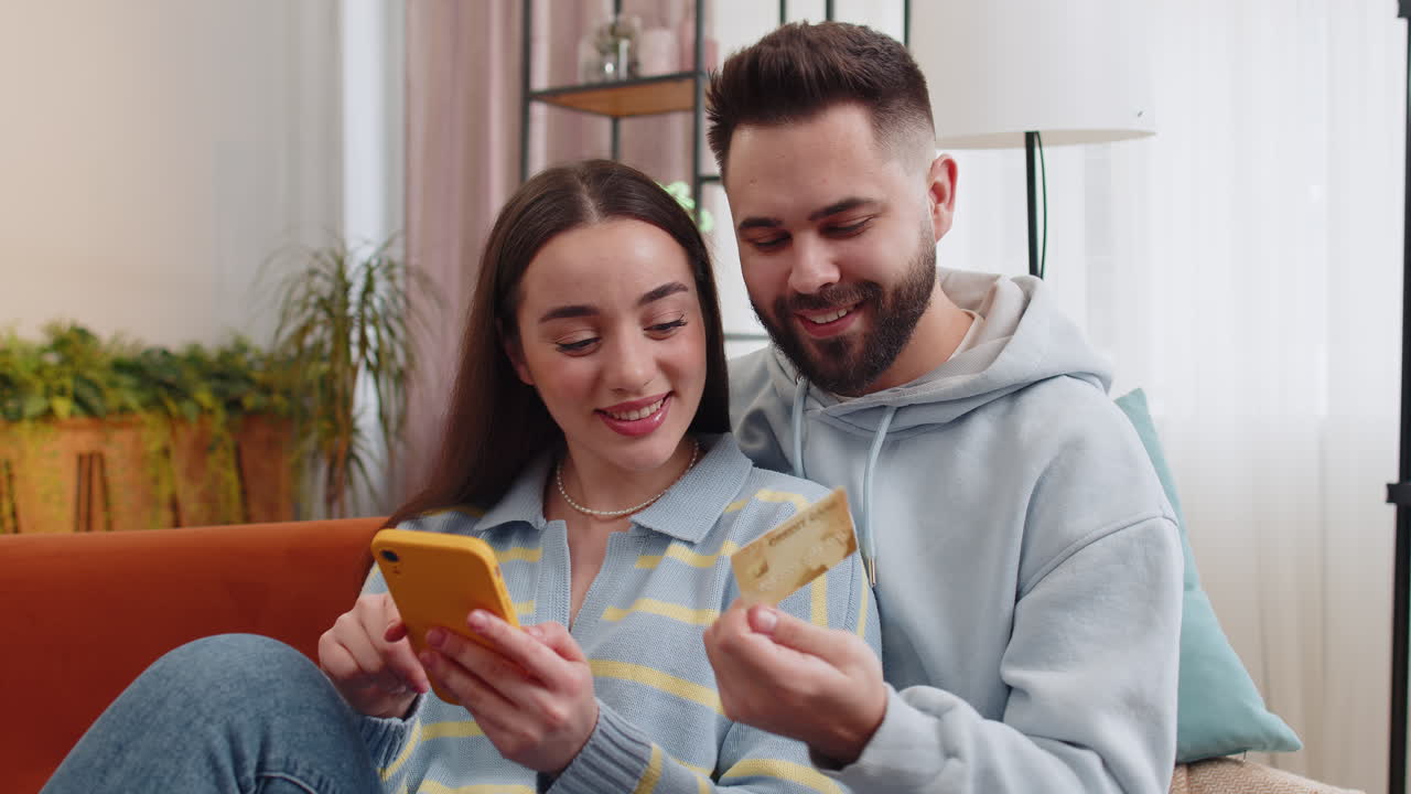 Family married couple using credit bank card smartphone transferring money purchases online shopping