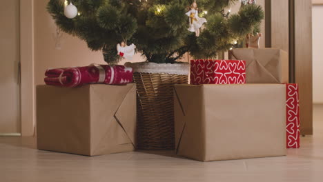 wrapped gifts under the christmas tree decorated with elements and christmas lights