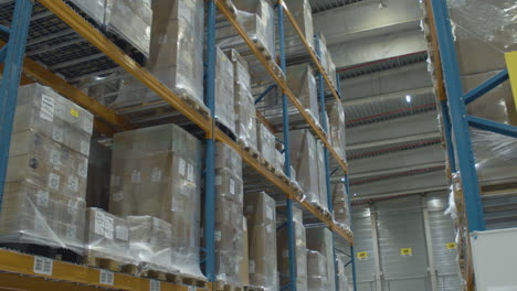 slow tilt up of high rack in busy industrial warehouse