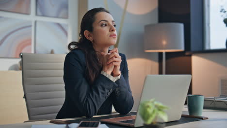 thoughtful ceo sitting desk laptop office closeup. smiling lady looking camera