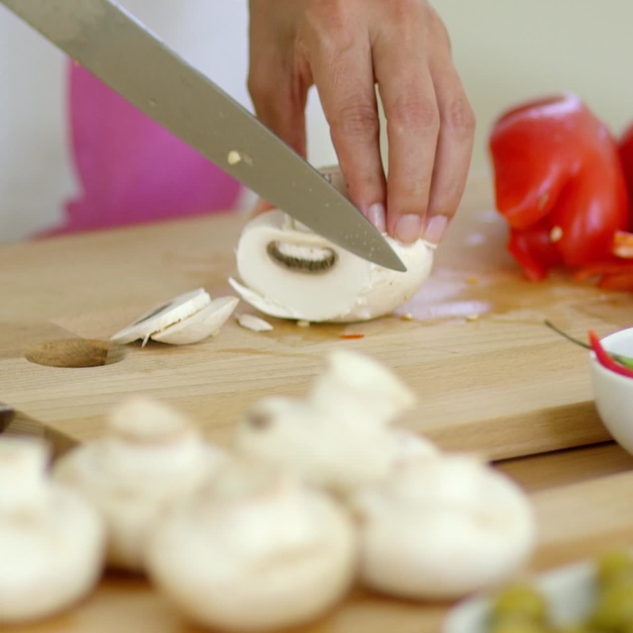 Housewife preparing dinner slicing fresh mushrooms