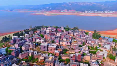 Overhead-natural-panoramic-large-agricultural-lands-with-corn,-wheat-and-terrace-farming-fields-in-rural-at-mountain-small-village-near-lake