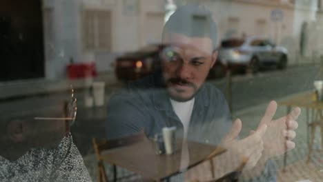 jóvenes guapos hablando en un café.
