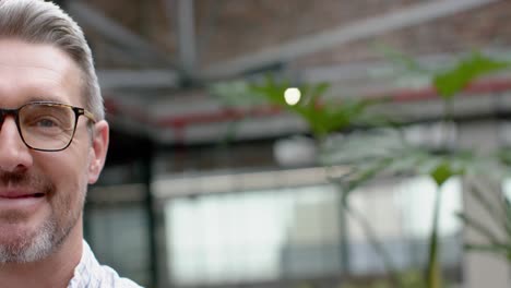 Half-face-portrait-of-caucasian-man-smiling-in-the-balcony-at-office,-copy-space