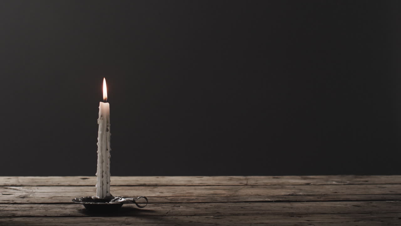 video de una vela de halloween con humo y espacio de copia sobre un fondo de madera y negro