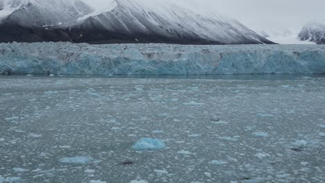 Eisblöcke-Schwimmen-Auf-Dem-Wasser-Vor-Einem-Gletscher-Mit-Schneebedeckten-Bergen-Im-Hintergrund-Im-Arktischen-Meer-Nördlich-Von-Spitzbergen