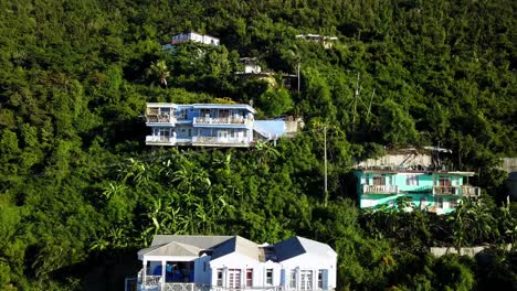 aerial crane shot of local homes on a hillside on bvi island tortola