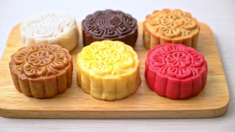 colourful chinese moon cake with mixed flavour on wood plate