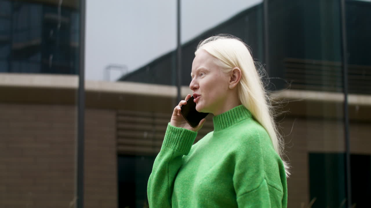 una mujer albina sonriente caminando por la calle