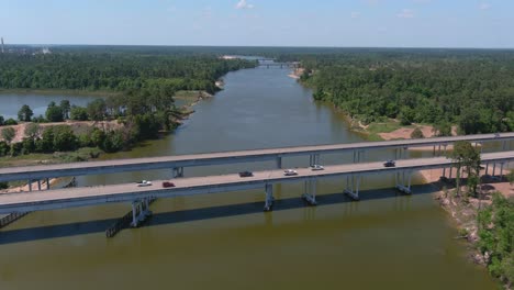 Aerial-of-cars-driving-on-bridge-that-crosses-over-the-San-Jacinto-River-in-Houston,-Texas