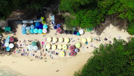 people relaxing in cozy beach of indonesia, aerial top down view