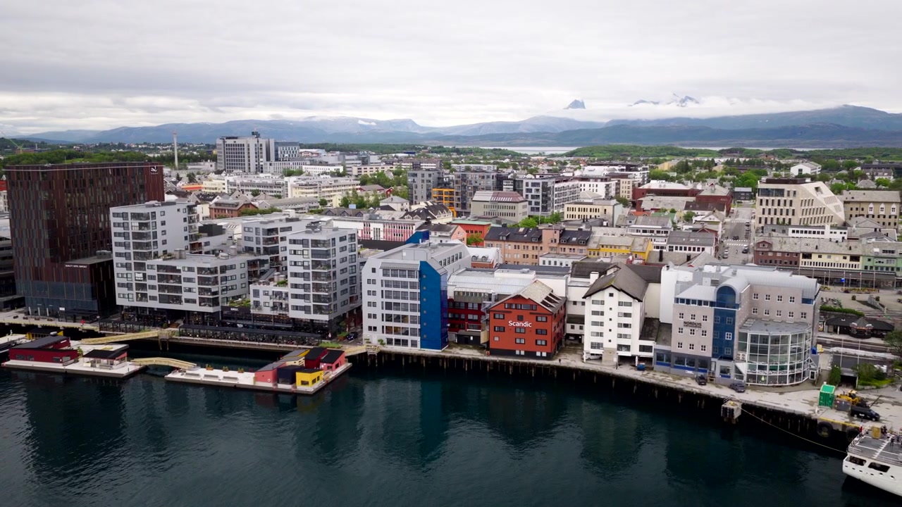 Porto cittadino, edifici moderni e paesaggio costiero a Bodo, Norvegia. Ripresa aerea all'indietro