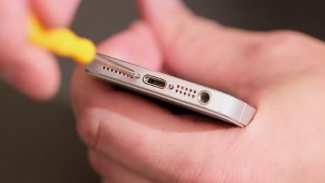 a smartphone with a green screen for your content. telephone and wood screws on a wooden table. close up